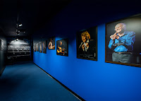 Art displayed along a blue theatre hallway